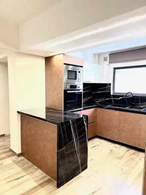 a kitchen with black counter tops and a microwave at Amaryllis in Plataniás