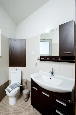 a bathroom with a sink and a toilet and a mirror at Sea Side House Rapanas in Falasarna