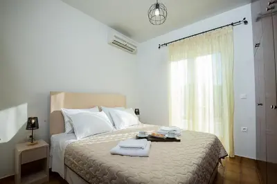 a white bedroom with a bed with towels on it at Sea Side House Rapanas in Falasarna
