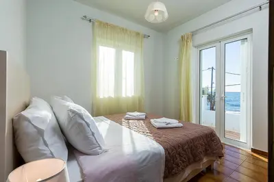 a bedroom with a bed with a view of the ocean at Sea Side House Rapanas in Falasarna