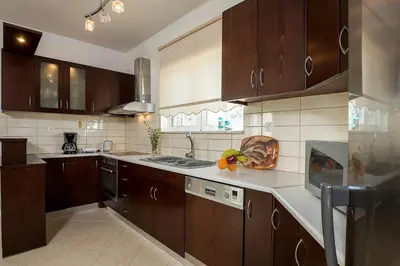 a large kitchen with wooden cabinets and a sink at Sea Side House Rapanas in Falasarna