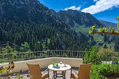 a balcony with a table and chairs and mountains at Apirathes Residence in Zoúrva