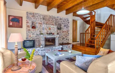 a living room with a stone fireplace at Apirathes Residence in Zoúrva