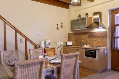 a kitchen with a table and chairs and a kitchen with a stove at Apirathes Residence in Zoúrva