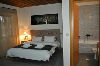 a bedroom with a bed and a bathroom with a tub at Apirathes Residence in Zoúrva