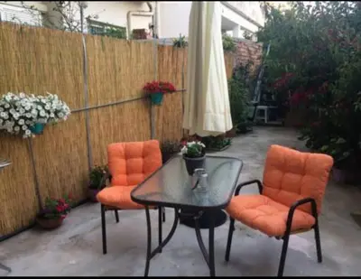 a patio with a table and two chairs and an umbrella at Konstantina's studio near the beach in Chania Town
