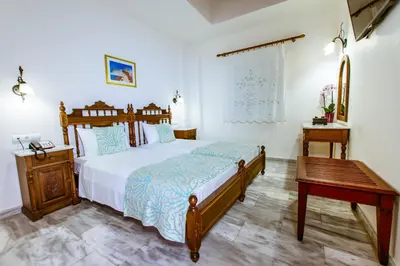 a bedroom with a bed and a wooden table at Anais Collection Hotels & Suites in Kato Daratso
