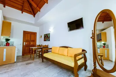 a living room with a yellow couch and a table at Anais Collection Hotels & Suites in Kato Daratso
