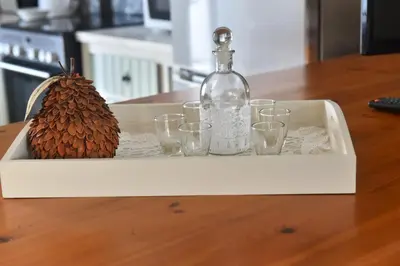 a tray with a bottle and glasses and a pine cone at Apartment in Koomkapi in Chania Town