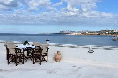 a table and chairs on a balcony overlooking the water at Apartment in Koomkapi in Chania Town