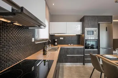 a kitchen with white cabinets and a counter top at Mirma Luxury Apartment in Chania Town