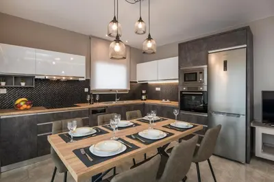 a kitchen with a wooden table and chairs in a kitchen at Mirma Luxury Apartment in Chania Town