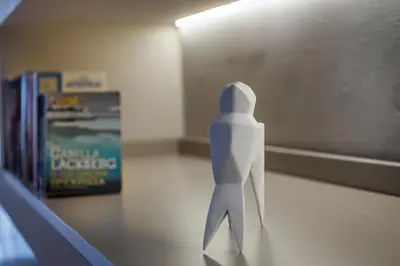 a paper person standing on a table next to books at Mirma Luxury Apartment in Chania Town