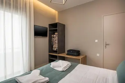 a bedroom with a bed and a tv and a window at Mirma Luxury Apartment in Chania Town