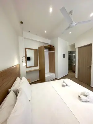 a bedroom with a large white bed with white pillows at Lissos Rooms Sougia in Sougia