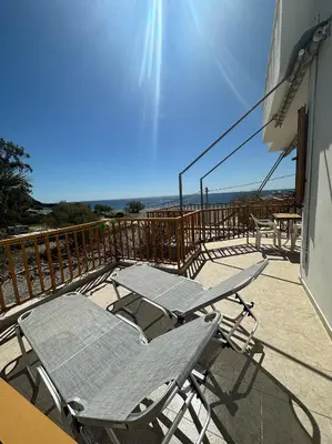 a deck with two lounge chairs on a balcony at Lissos Rooms Sougia in Sougia