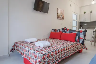 a living room with a couch with red pillows at The 3 Brothers' Apts in Chania Town