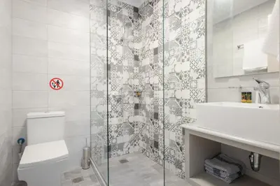 a bathroom with a shower and a toilet and a sink at The 3 Brothers' Apts in Chania Town