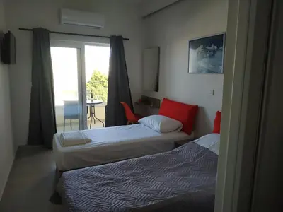two beds in a hotel room with a balcony at The 3 Brothers' Apts in Chania Town