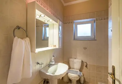 a bathroom with a sink and a toilet and a mirror at Villa Helen 200m from the beach in Tersanas BY APOKORONAS-VILLAS in Tersanas