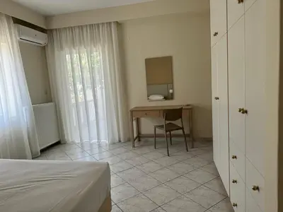 a bedroom with a desk and a table with a mirror at Niki's Apartment in Palaiochóra