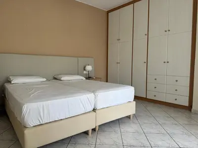 a bedroom with a large bed and white cabinets at Niki's Apartment in Palaiochóra