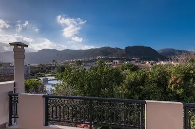 a balcony with a view of a city and mountains at Niki's Apartment in Palaiochóra