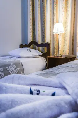 two beds in a bedroom with a lamp and curtains at Aromatic Home in Kissamos
