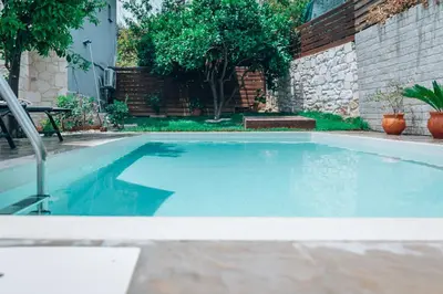 a swimming pool with blue water in a backyard at Villa Stafidaki in Stalos