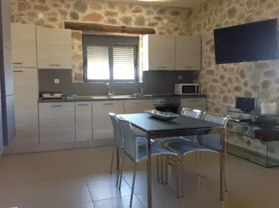 a kitchen with white cabinets and a table and chairs at VILLA ASTERAKI private pool, magic sunsets, near Elafonisi in Ãyios FÃ³tios