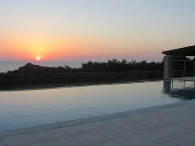 a swimming pool with a sunset in the background at VILLA ASTERAKI private pool, magic sunsets, near Elafonisi in Ãyios FÃ³tios