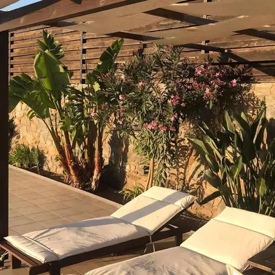 a patio with two lounge chairs and some plants at VILLA ASTERAKI private pool, magic sunsets, near Elafonisi in Ãyios FÃ³tios