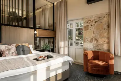 a bedroom with a bed and a chair at Divino Suites Chania in Chania Town