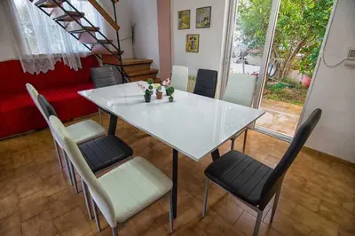a white table and chairs with flowers in a room at Thanasis Villa in Kounoupidhianá