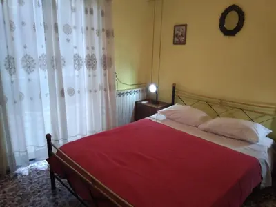 a bedroom with a bed with a red blanket at Thanasis Villa in Kounoupidhianá