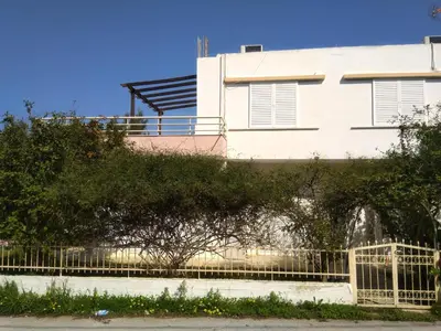 a white house with a fence in front of it at Thanasis Villa in Kounoupidhianá
