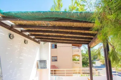 a wooden pergola on top of a building at Thanasis Villa in Kounoupidhianá