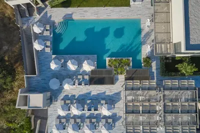 an overhead view of a pool with tables and chairs at Atlantica Amalthia Beach Hotel - Adults Only in Agia Marina Nea Kydonias