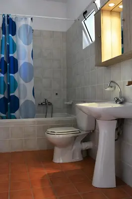 a bathroom with a toilet and a sink and a tub at Raph's Studios-Apts By The Sea in Agia Marina Nea Kydonias