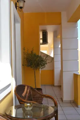 a glass table and a chair in a hallway at Raph's Studios-Apts By The Sea in Agia Marina Nea Kydonias