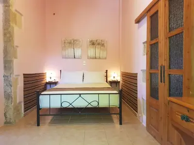 a bedroom with a bed in a room with two lamps at Wood & Stone in Kissamos