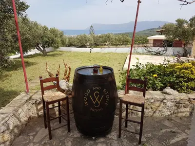two chairs and a barrel sitting between two chairs at Wood & Stone in Kissamos