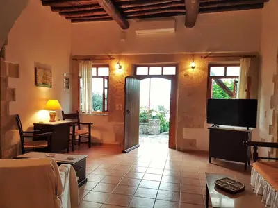 a living room with a television and a living room with a table at Wood & Stone in Kissamos