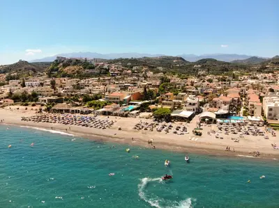 a beach with a bunch of people in the water at Athina Suites Luxury Suites Near The Sea Platanias in Plataniás