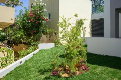 a garden with a small tree in the grass at Athina Suites Luxury Suites Near The Sea Platanias in Plataniás