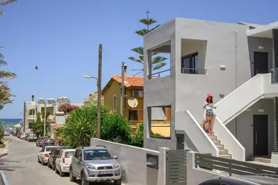 a woman is standing on the stairs of a house at Athina Suites Luxury Suites Near The Sea Platanias in Plataniás
