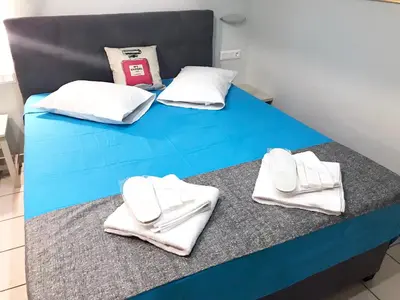 a blue bed with white towels on top of it at Odyssey Apartment in Palaiochóra
