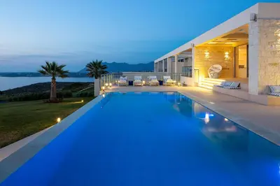 a villa with a swimming pool at night at Elias Luxury Villa in Kalathas