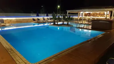 a swimming pool at night with blue lighting at Sunny Suites in Maleme