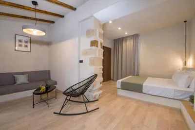 a bedroom with a bed and a chair and a couch at Cretan Berry Sarpaki in Chania Town